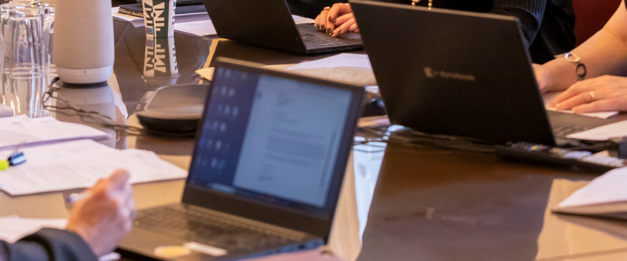 A decorative image showing a laptop on a wooden table
