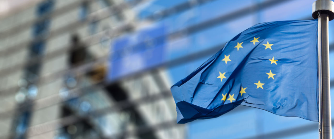 The EU flag displayed next to a modern office buildint