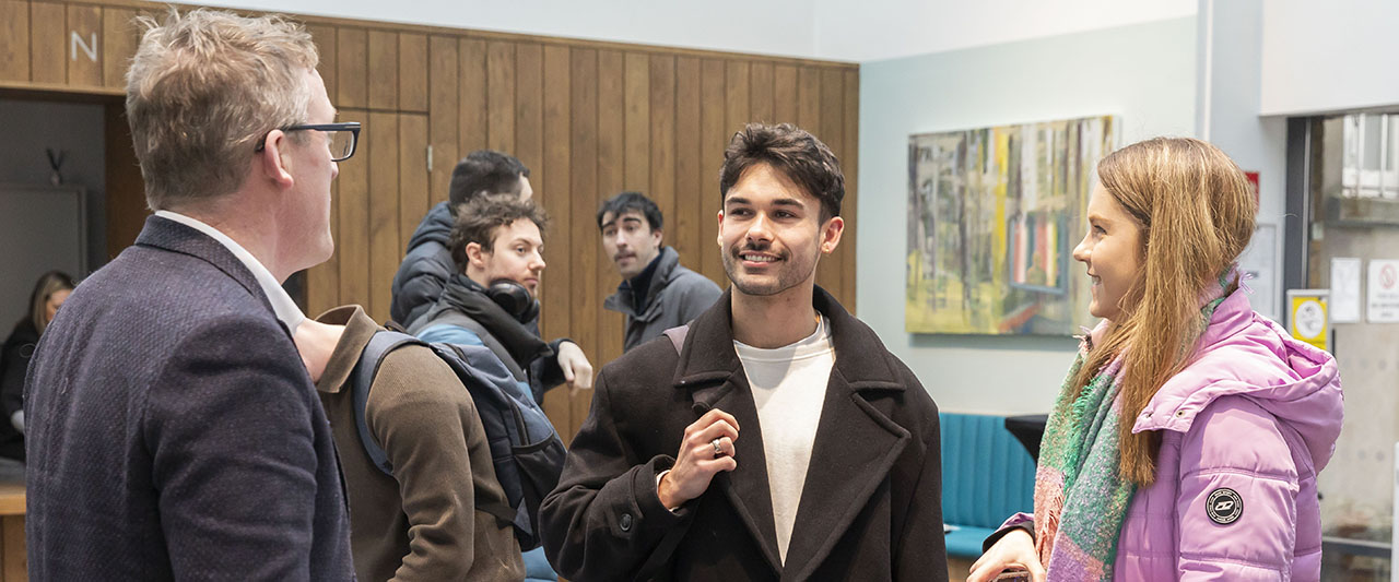 A trainee having a friendly conversation with a course manager at the Law School