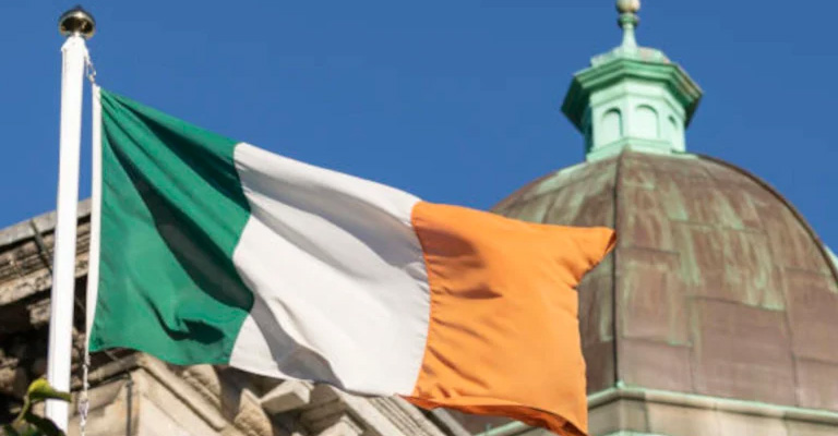 The Irish flag at Blackhall Place with a classical building cupola in the background